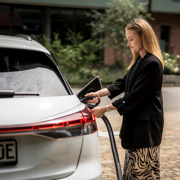 Frau laedt E-Auto